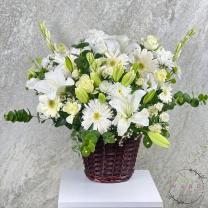 white and green flowers in a basket on a gray background
