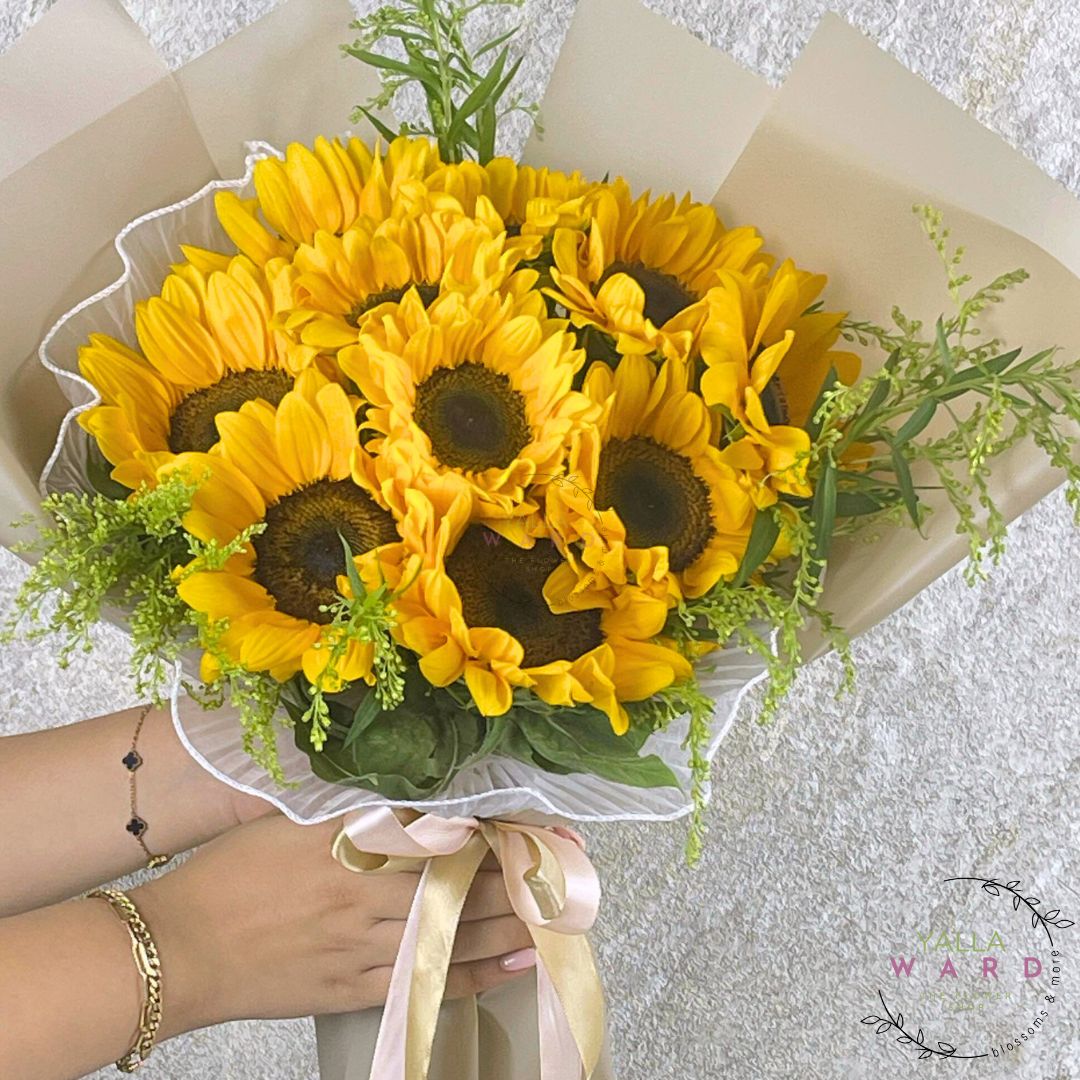 Bouquet of sunflowers held by a person with a blurred background