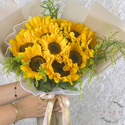 Bouquet of sunflowers held by a person with a blurred background