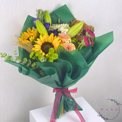 Bouquet of flowers wrapped in green paper with a red ribbon on a white background