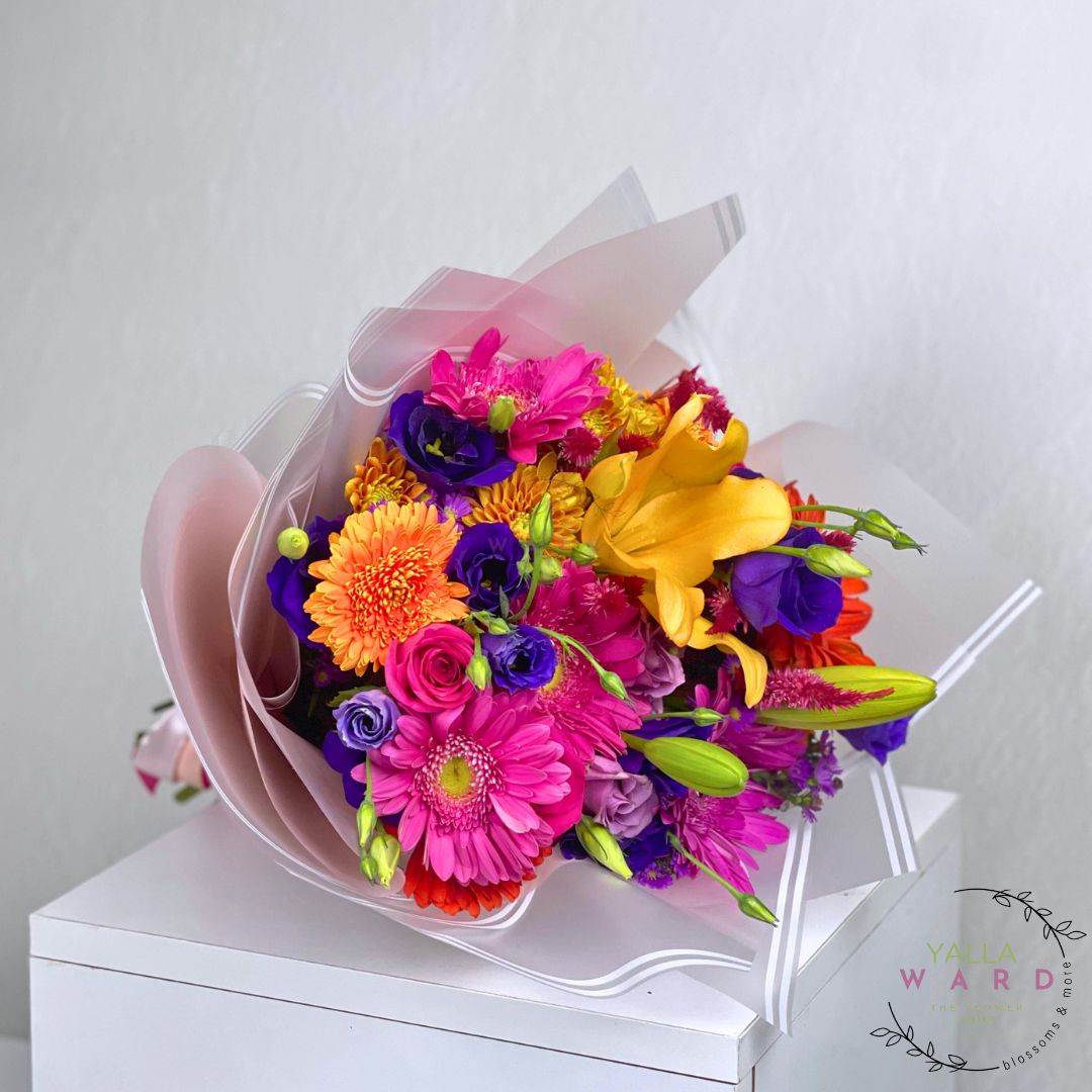 Colorful bouquet of flowers on a pink wrap with 'Your Ward' branding.