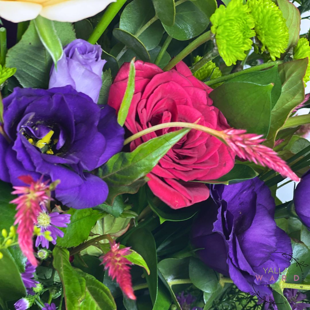 Bouquet of colorful flowers including purple, pink, and green.