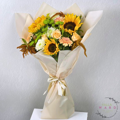 Bouquet of sunflowers and other flowers wrapped in white paper on a light gray background
