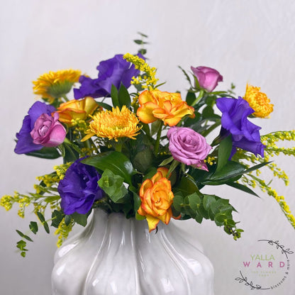 Colorful vase of flowers in a white vase on a light gray background