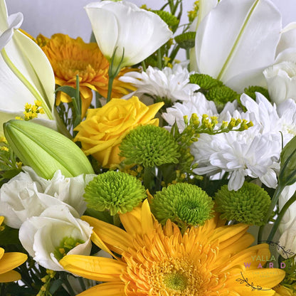 Bouquet of yellow, white, and green flowers with a visible brand logo.
