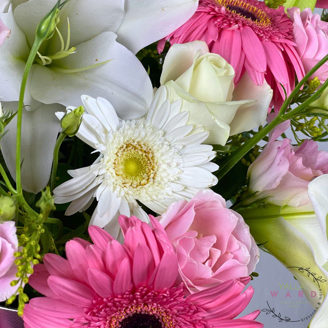 flowers including white daisies, pink and yellow gerberas, and greenery.