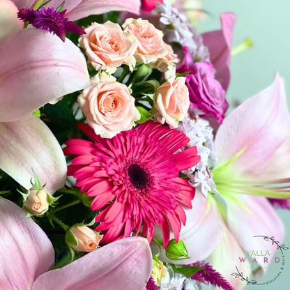 Bouquet of flowers with pink and purple colors, featuring a prominent pink gerbera daisy.