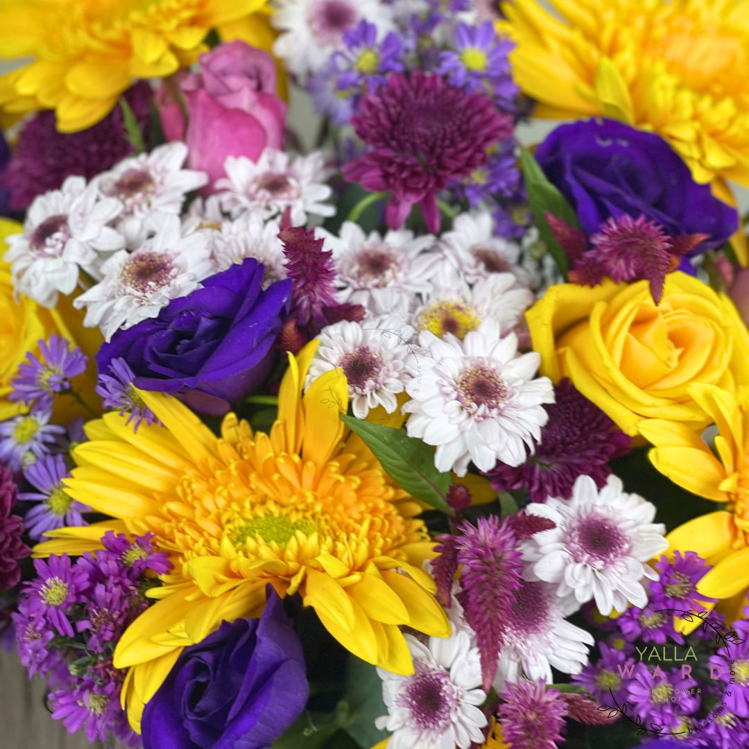 Bouquet of colorful flowers including yellow, purple, and white.