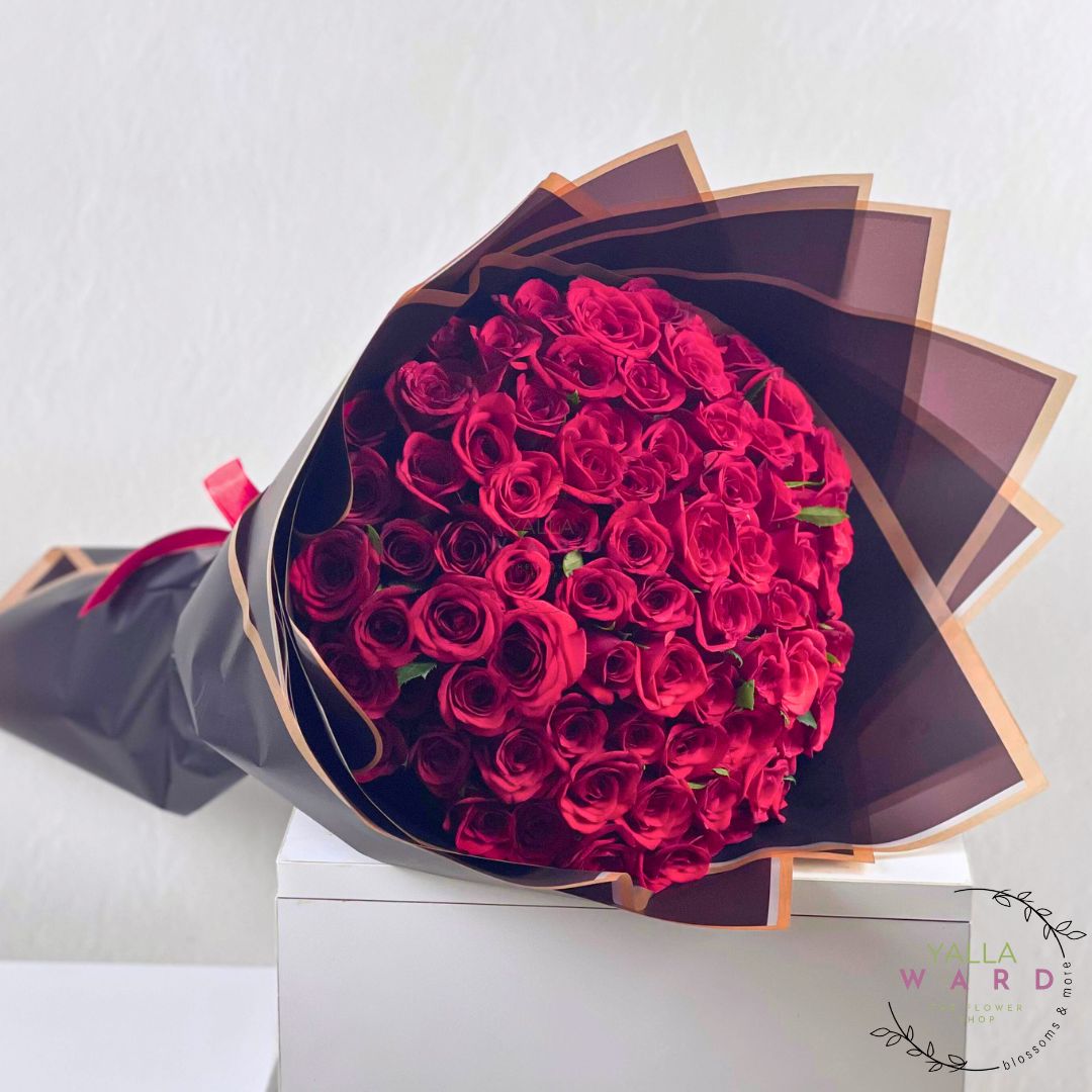Bouquet of red roses wrapped in black paper on a white background