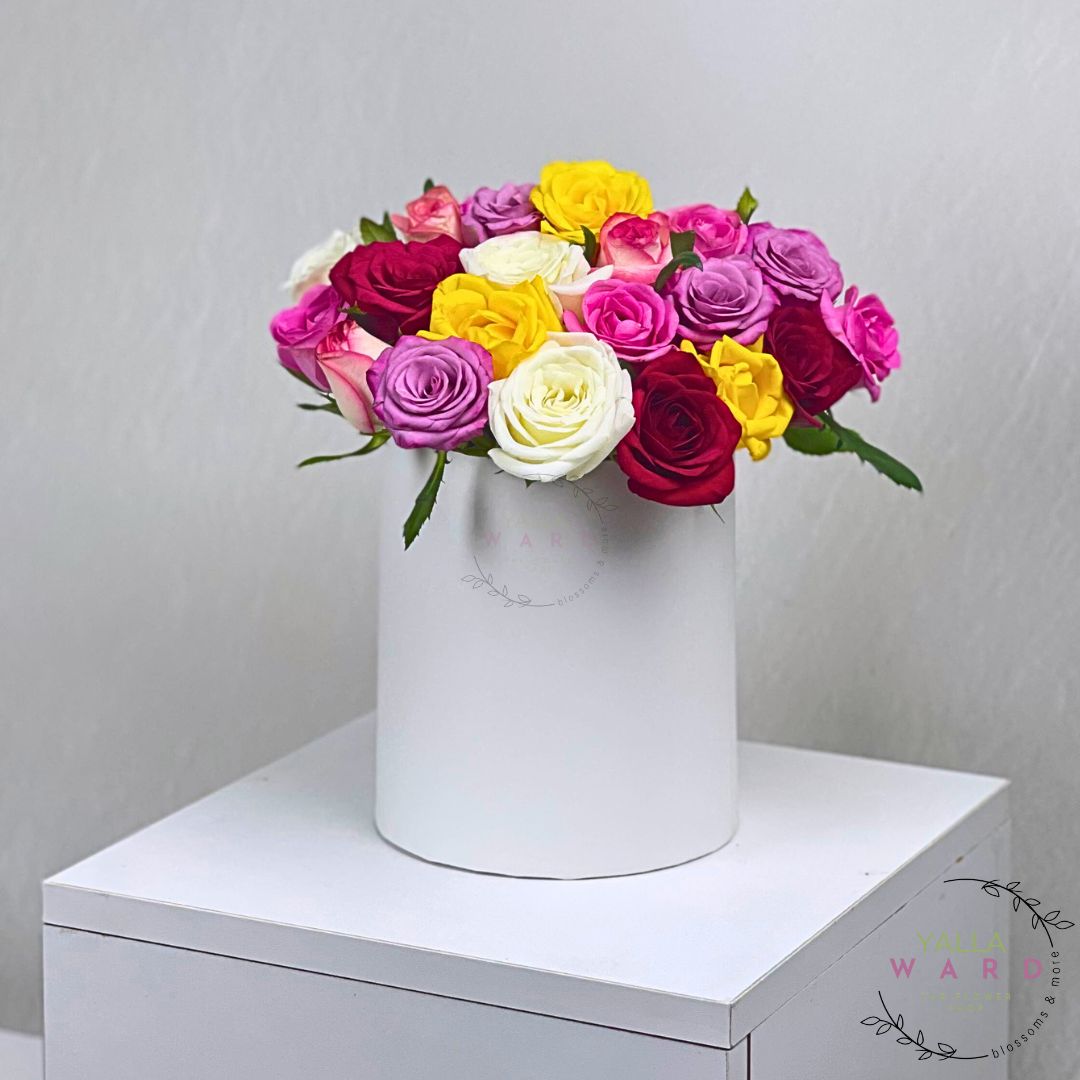 mix roses in a white box on a white surface with a light gray background.