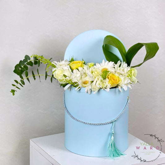 Blue box with flowers on a white surface