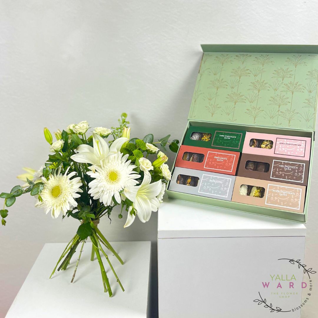 Bouquet of white flowers next to a box of chocolates on a white surface with 'Yalla Ward' branding.