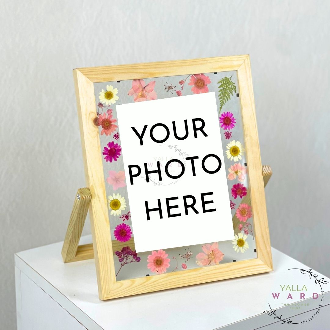 Floral photo frame with 'Your Photo Here' text on a white surface.