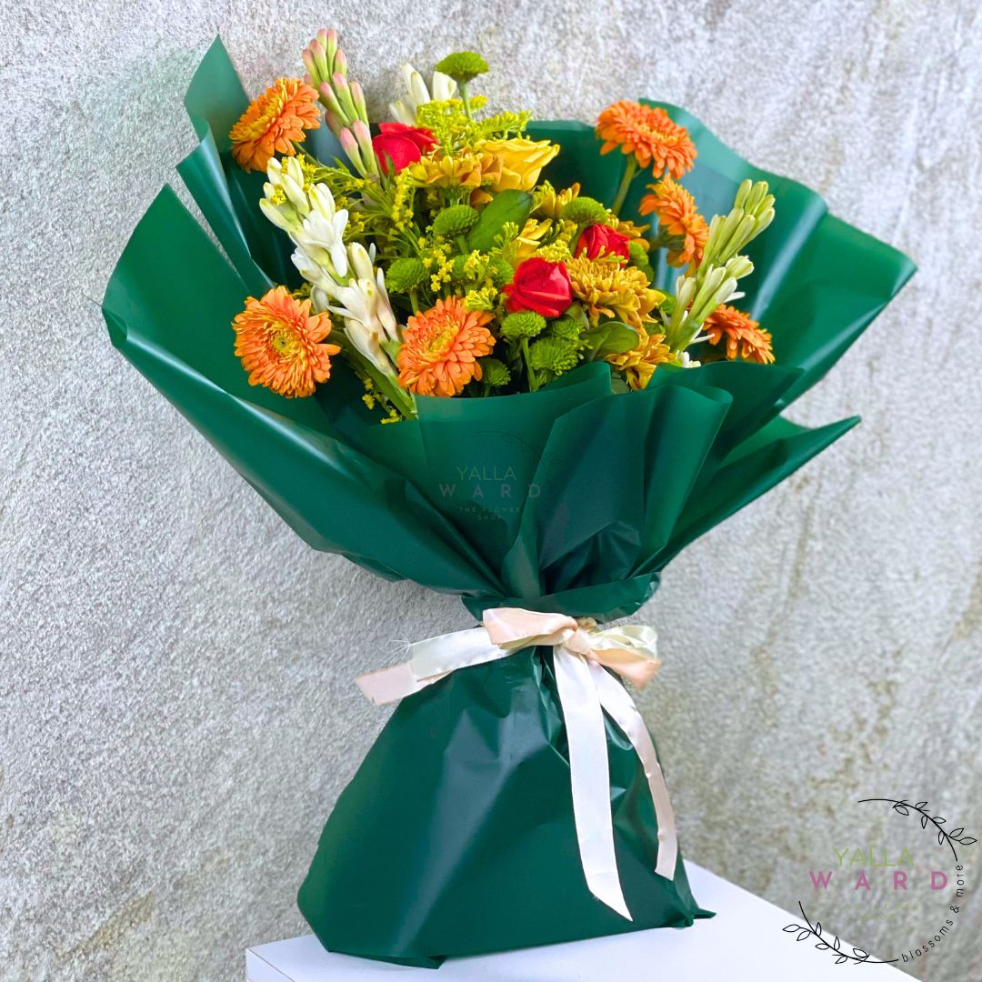 Bouquet of flowers wrapped in green paper with a white ribbon on a light gray background